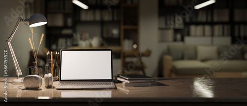 Workspace tabletop close-up with laptop mockup and decor over blurred cozy living room at night © bongkarn