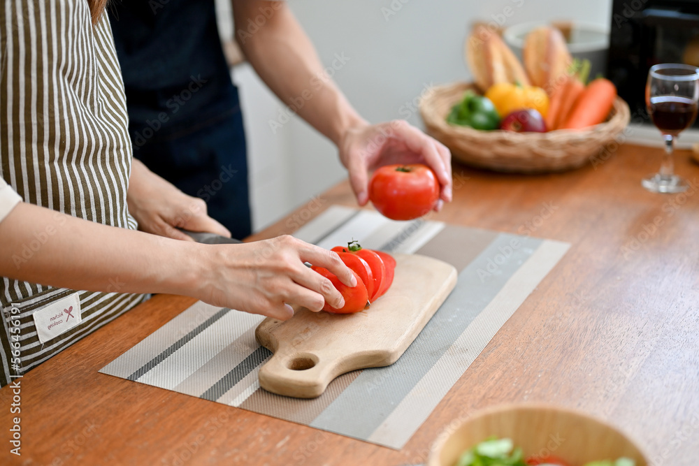 Lovely couple cooking their breakfast together in the kitchen, preparing salad's ingredients together Lovely couple cooking their breakfast together in the kitchen, preparing salad's ingredients together