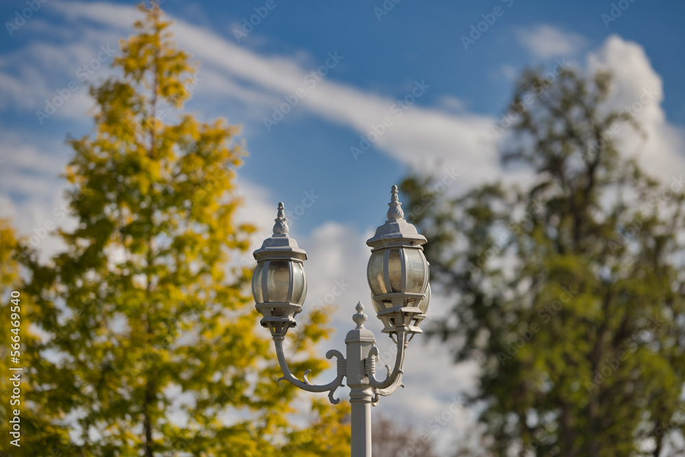 Classic charm of white retro street lamps in front of trees