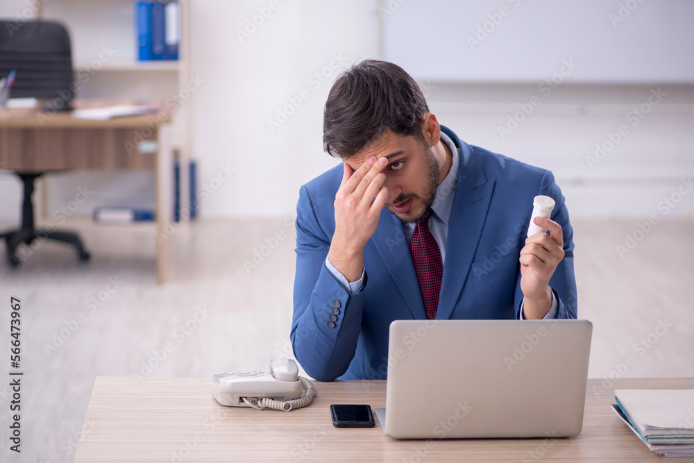 Young male employee feeling bad at workplace Young male employee feeling bad at workplace