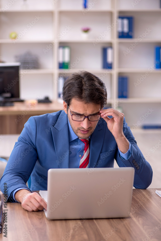 Young male employee working in the office Young male employee working in the office