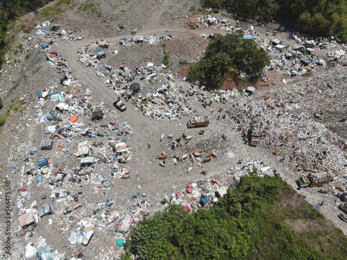 Aerial view of a city dump center full of trash. Herd of cows eating garbage in a landfill. Ecology and health issues.