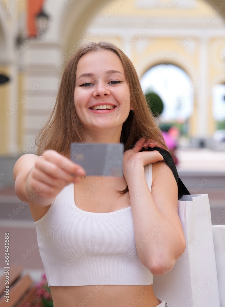 Φωτογραφία Vertical photo of Happy blurred young woman is showing, holding credit bank card