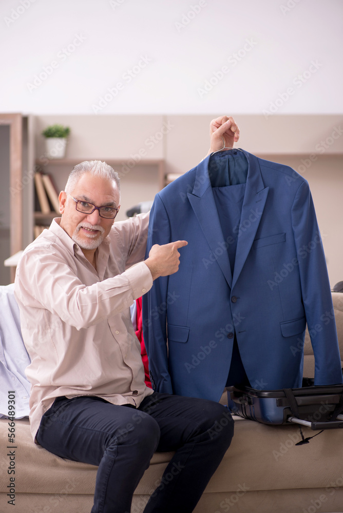 Fototapeta premium Old man preparing for trip at home