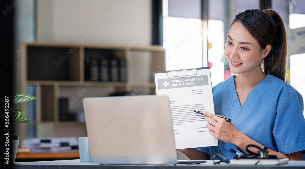 Female positive doctor having online consultation with patient on laptop in clinic office.