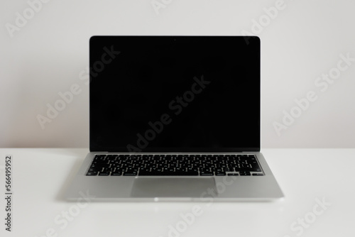 Laptop with blank screen on white table