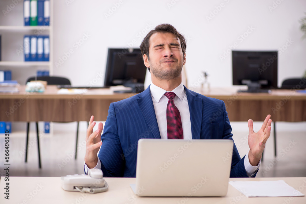 Young male employee working in the office Young male employee working in the office