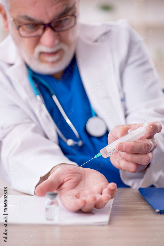 Old male doctor working in the clinic Old male doctor working in the clinic