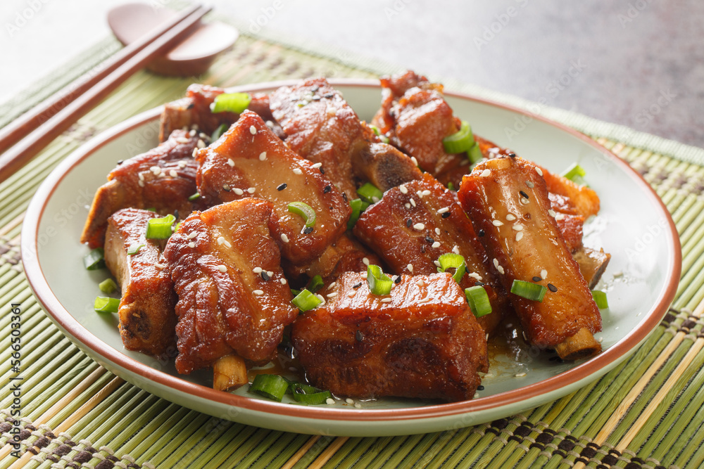 Glazed pork short ribs in sweet and sour sauce in Asian style close-up in a plate on the table. horizontal Glazed pork short ribs in sweet and sour sauce in Asian style close-up in a plate on the table. horizontal