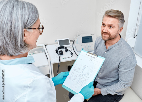 Male patient has good tympanometry results after hearing test with audiologist at hearing clinic. Impedance audiometry and tympanometry photo