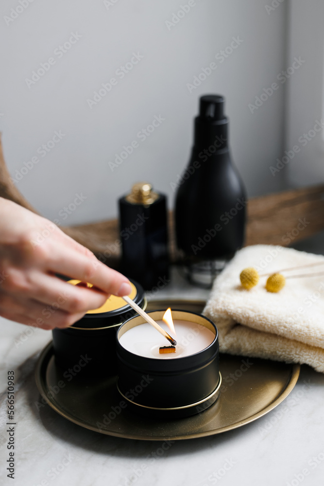 Soy scented candles in metal jars, boxes. The candle is lit by a girl