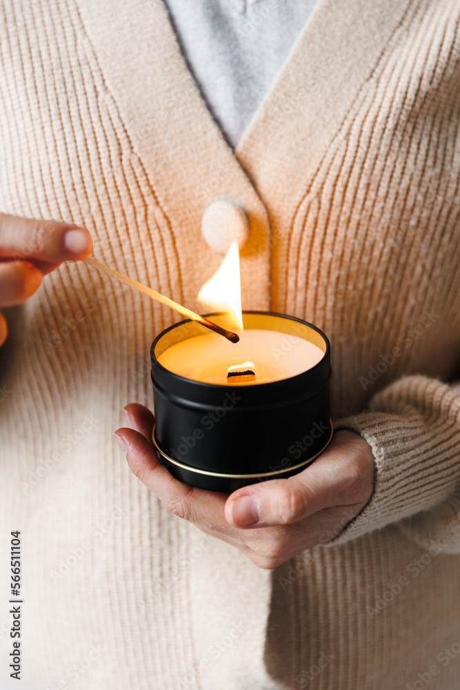 Soy scented candles in metal jars, boxes. Candle held by a girl against