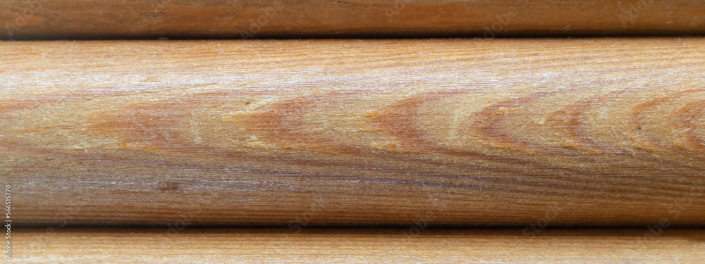 Textured background of a wooden round bar. Wood texture background board of rounded logs