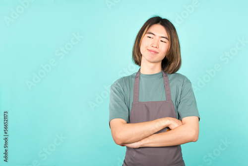 Asian man with apron smiling while crossing arms