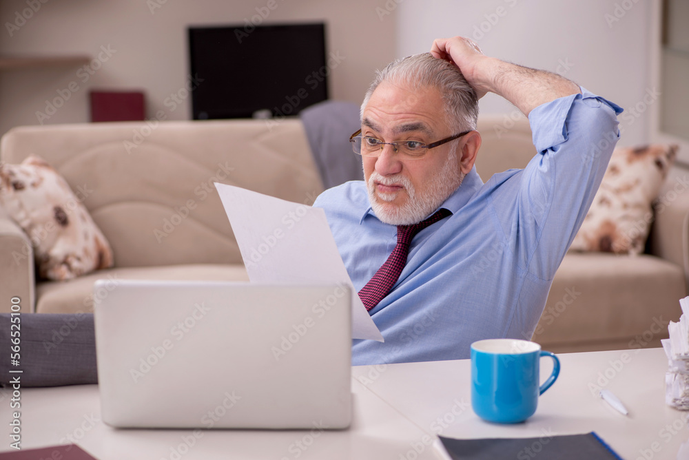 Old male employee working from home during pandemic