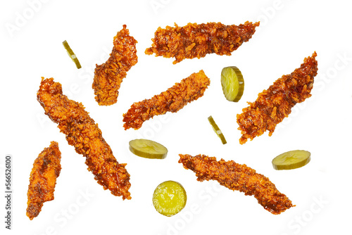 Fried chicken breast fillet strips in different angles flying with jalapeño pickles isolated on white with clipping mask.