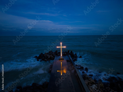 Photography christian cross standing on pier in the sea or ocean with dramatic sky at night