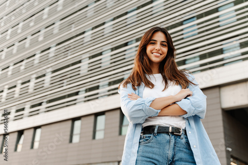 Obraz na plátně Confident young caucasian woman standing in the city looking to the camera with