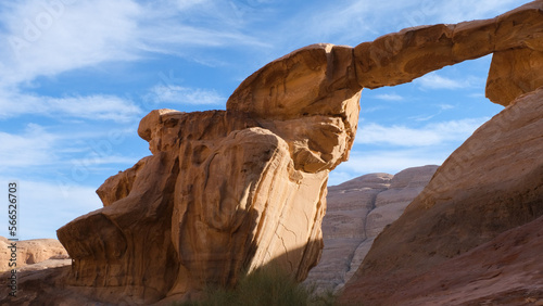 Unique sandstone archway in the vast mountainous landscape of Wadi Rum desert in Jordan, Middle East 