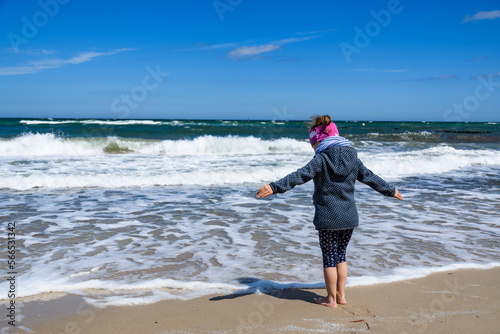 Kind mit offenen Armen am Meer