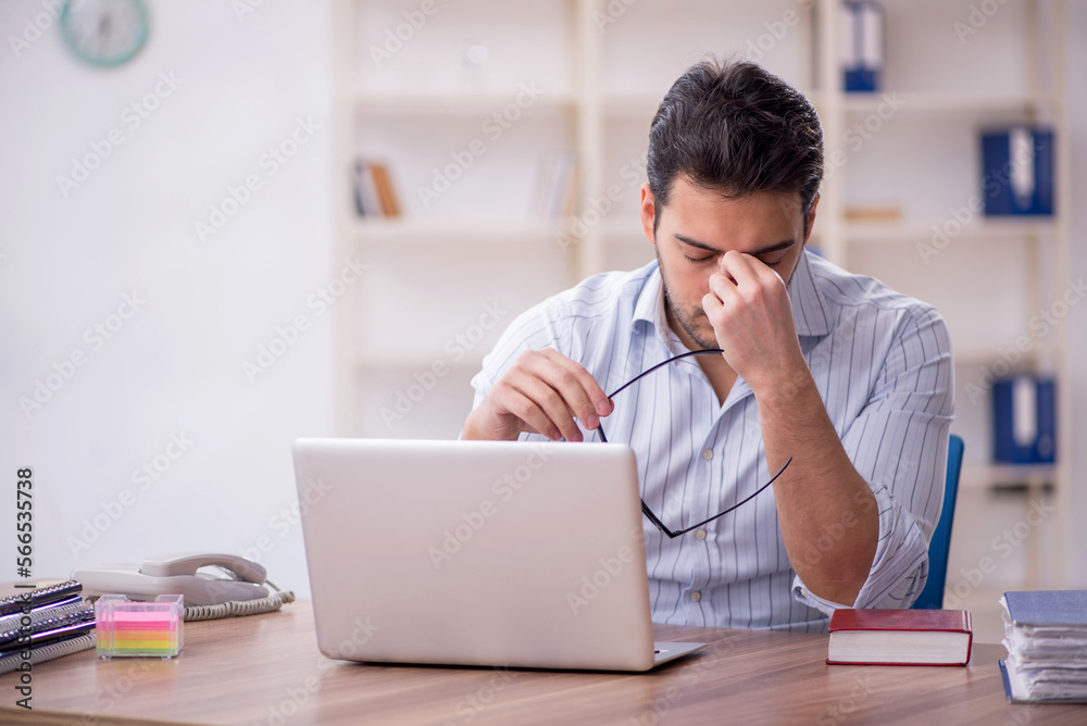 Young male employee working in the office Young male employee working in the office