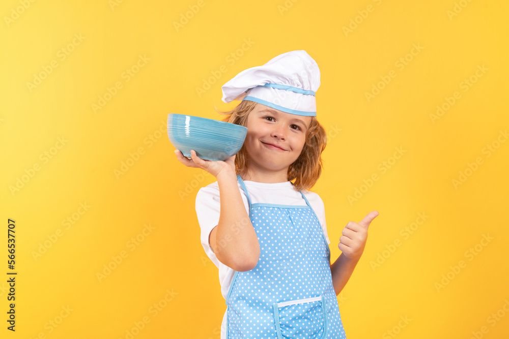 Kid chef cook with cooking bowl. Child wearing cooker uniform and chef hat preparing food on kitchen, studio portrait. Cooking, culinary and kids food concept. Kid chef cook with cooking bowl. Child wearing cooker uniform and chef hat preparing food on kitchen, studio portrait. Cooking, culinary and kids food concept.