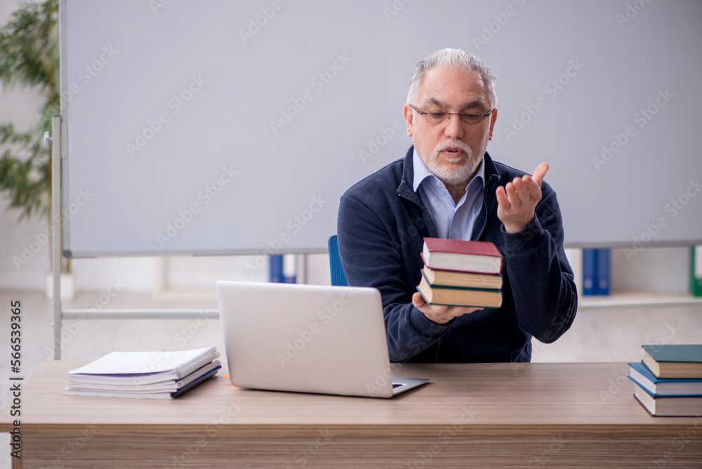 Old male teacher in the classroom Old male teacher in the classroom