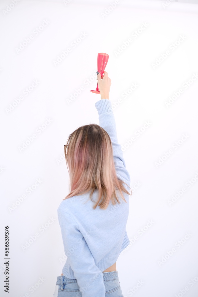 Young and attractive happy woman from her back, holding a rose and a glass of beverage on her hands. Single life. Happy girl. Freedom Young and attractive happy woman from her back, holding a rose and a glass of beverage on her hands. Single life. Happy girl. Freedom