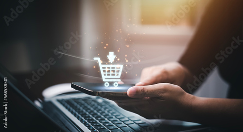 Fotografia, Obraz Businessman using a laptop with online shopping concept, marketplace website with virtual interface of online Shopping cart part of the network, Online shopping business with selecting shopping cart
