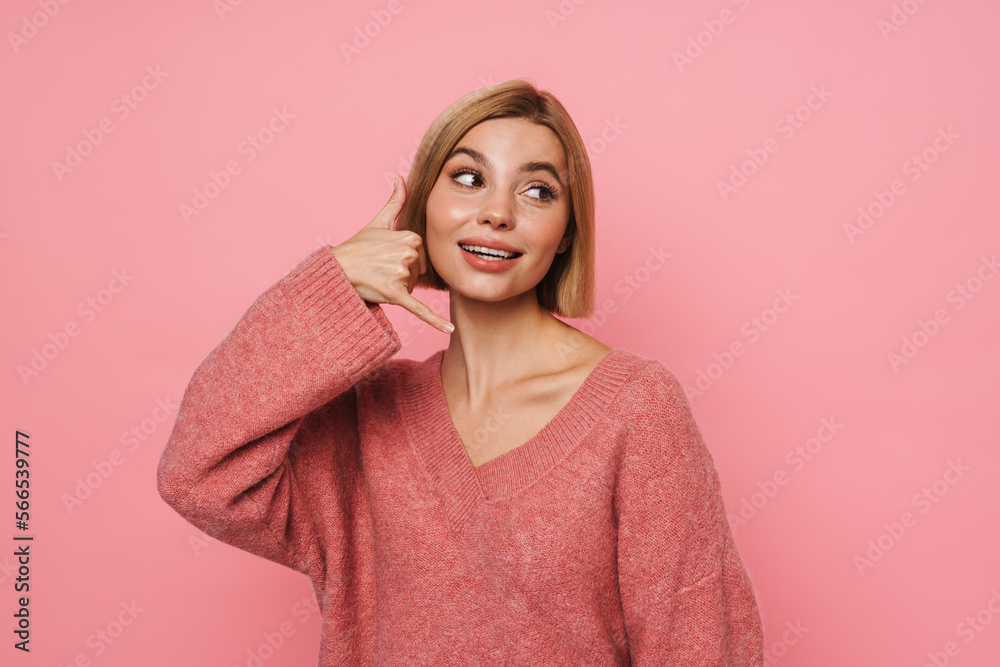 Young blonde woman with short hair doing call gesture Young blonde woman with short hair doing call gesture