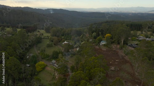 Smooth aerial accent over homestead where small controlled fires can be seen burning in the distance. photo