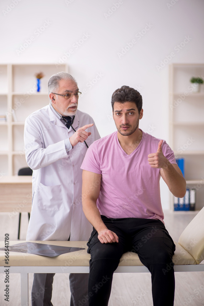 Fototapeta premium Young male patient visiting old male doctor
