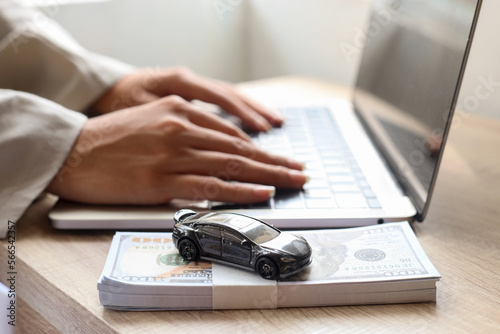 Close up of woman hands typing on laptop applying car loan, finance for car concept.  photo