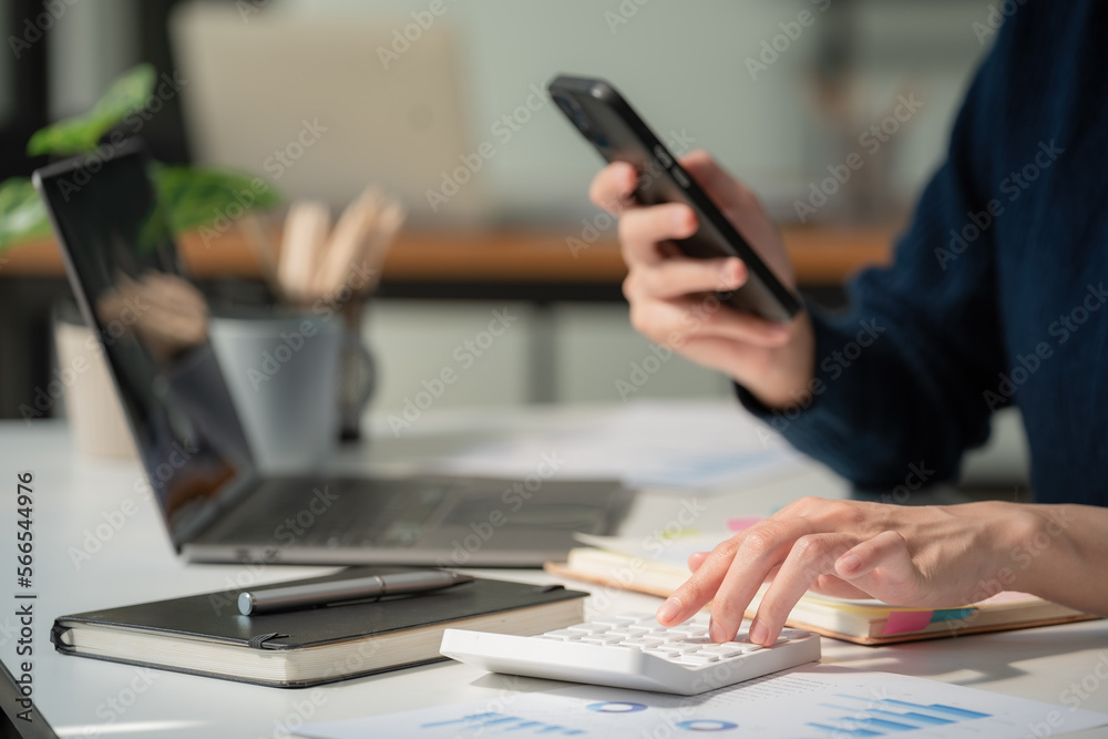 Close-up portrait of businesswoman accountant using calculator and laptop for matching financial data saving in office room, Business financial, tax, accounting concept Close-up portrait of businesswoman accountant using calculator and laptop for matching financial data saving in office room, Business financial, tax, accounting concept