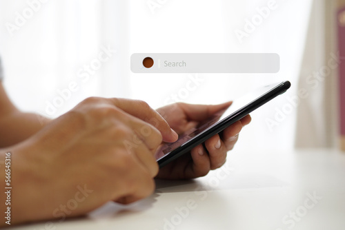 Young man sitting on smartphone in communication concept room and working remotely  spot focus 