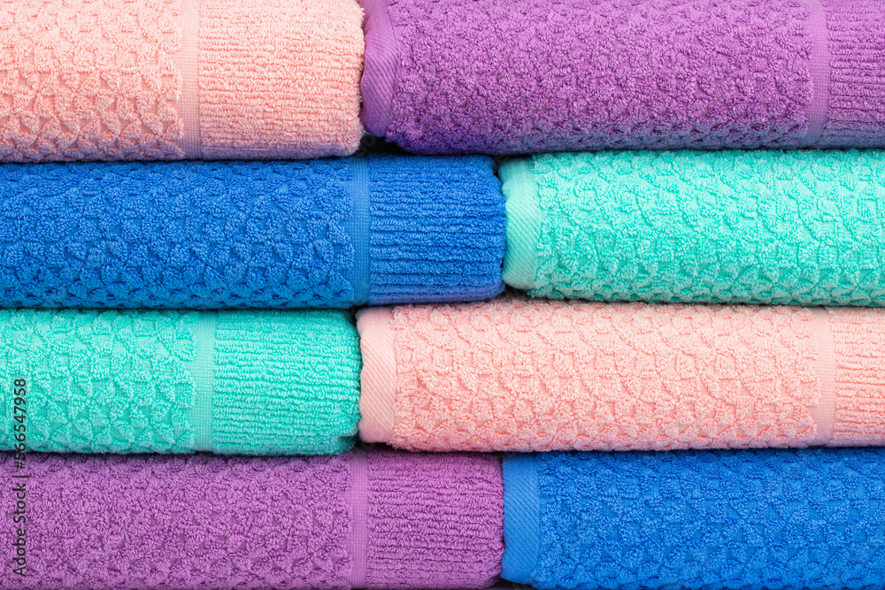 multicolored terry towels, rolled up and stacked on the table multicolored terry towels, rolled up and stacked on the table