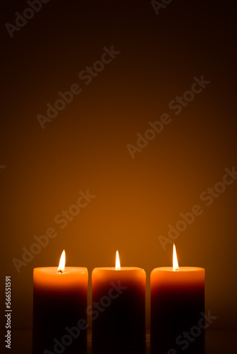 three burning candles in the dark. Memories and blessings