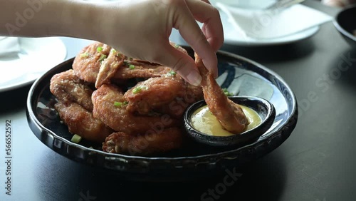 4k footage side panning, Bowl of buffalo wings with red and spicy sauce. fried chicken wings served with mustard sauce for dipping in fast food restaurant. Delicious homemade fried chicken dinner