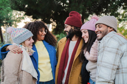 Fotografi Group of young people smiling and talking outdoors with autumnal clothes