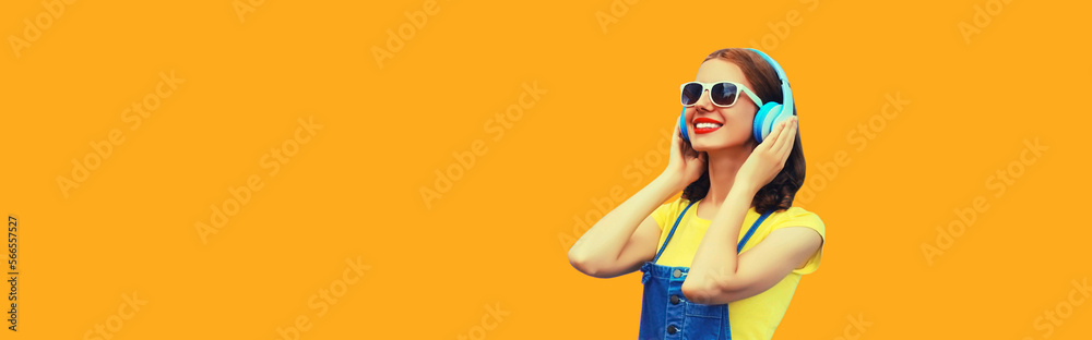 Portrait of happy smiling young woman with headphones listening to music on yellow background Portrait of happy smiling young woman with headphones listening to music on yellow background