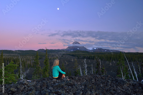 Woman sitting along McKenzie Pass with North Sister volcano in the back,Oregon,USA photo