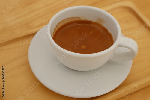 Espresso coffee in white ceramic cup on wooden table background. 