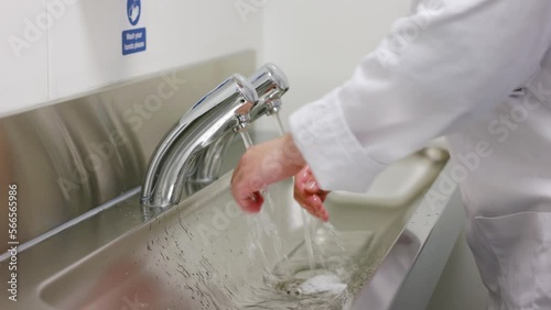 Close up of chef washing hands in commercial kitchen environment