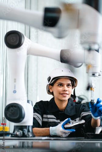 Computer science development engineer working on robotic arm connection and control using tablet software. Woman in industry 4.0 robotic engineering workshop in electronic futuristic technology center