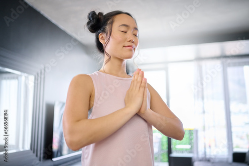 Yoga, meditate and woman with gratitude for her mind, peace and calm start to the morning. Hope, freedom and Asian girl in the living room for a mindset exercise, spiritual faith and mindfulness