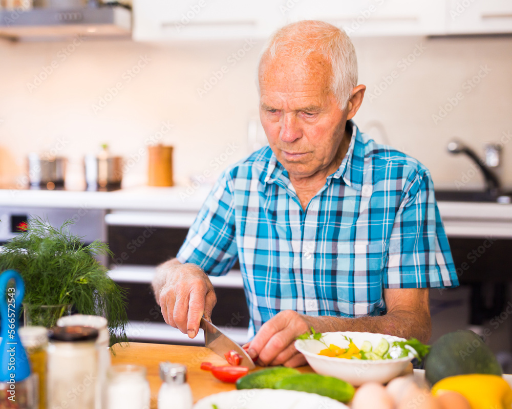 senor man preparing fresh vegetable salad at home in the kitchen senor man preparing fresh vegetable salad at home in the kitchen