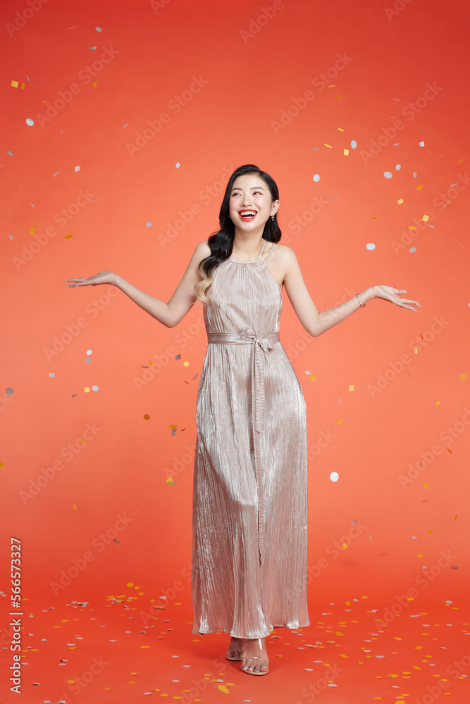 Happy woman in shiny trendy clothes rejoicing, posing with confetti Happy woman in shiny trendy clothes rejoicing, posing with confetti