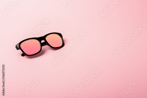 Black sunglasses with Multicolor Mirror Lens on pink background. Polarized sunglasses with UV protection.