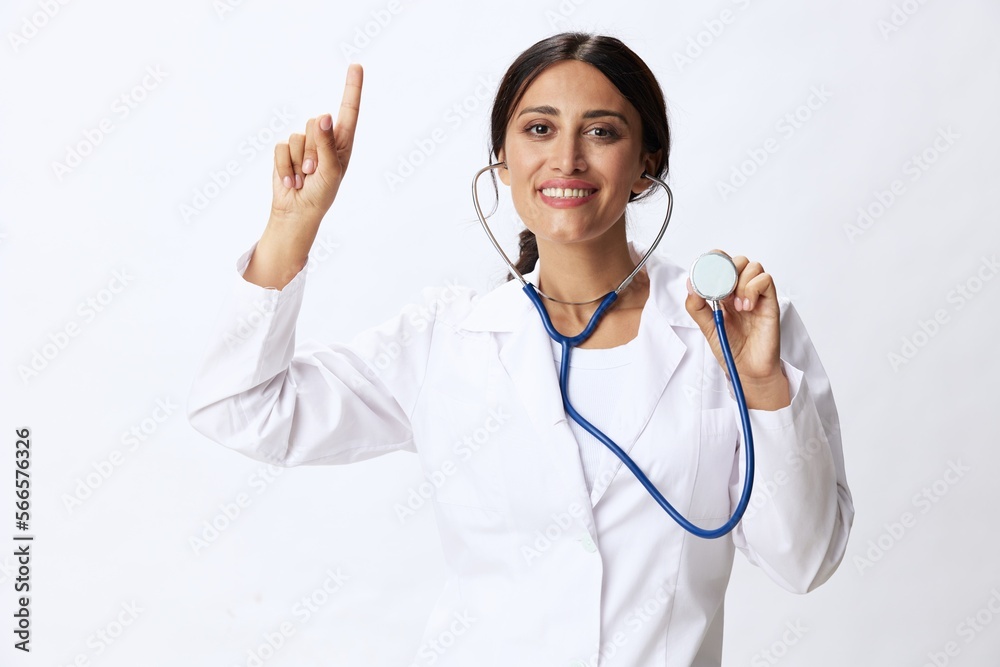 Woman doctor with stethoscope in hand in medical gown on white nurse background, consequences of covid-19, noise in lungs, concept of health and science Woman doctor with stethoscope in hand in medical gown on white nurse background, consequences of covid-19, noise in lungs, concept of health and science