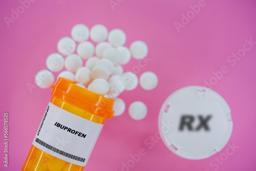 Ibuprofen Rx medicine pills in plactic vial with tablets. Pills spilling   from yellow container on pink background.